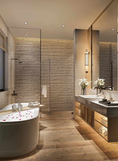 Salle de bain moderne avec baignoire ovale, pétales de rose, douche vitrée, double vasque, grand miroir, mur texturé et sol bois.